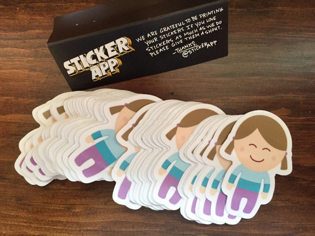 Stacks of Munchkin Report character stickers on a wooden table.
