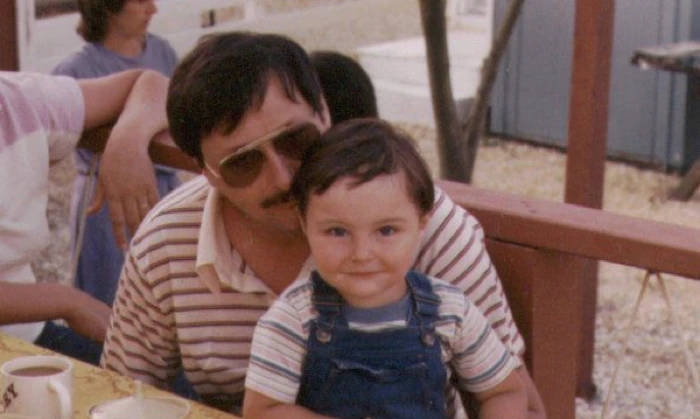 Robert A. Sobers, Sr., seated with a young child on his lap.